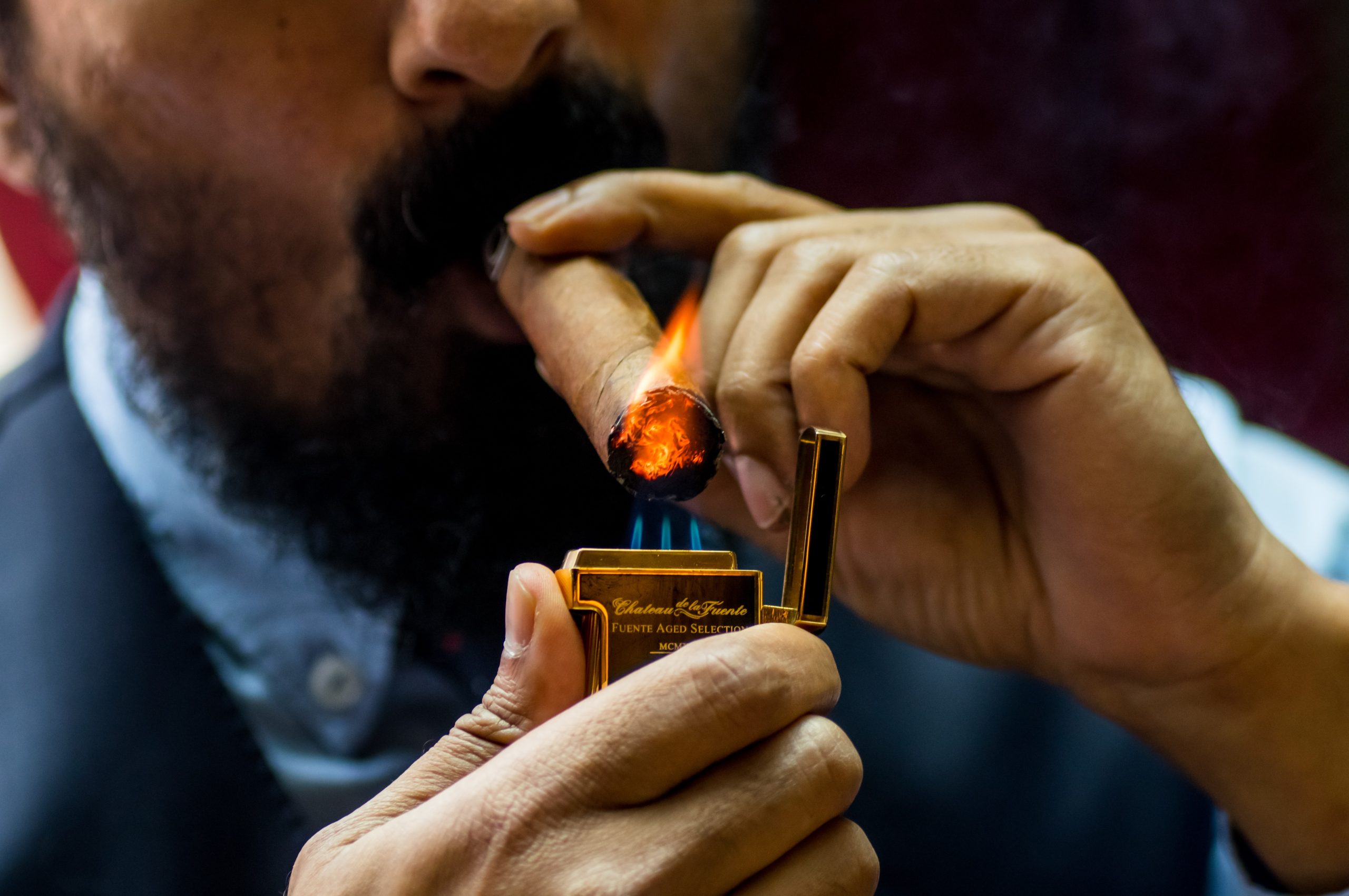 Bearded man lighting cigar after choosing the perfect cigar